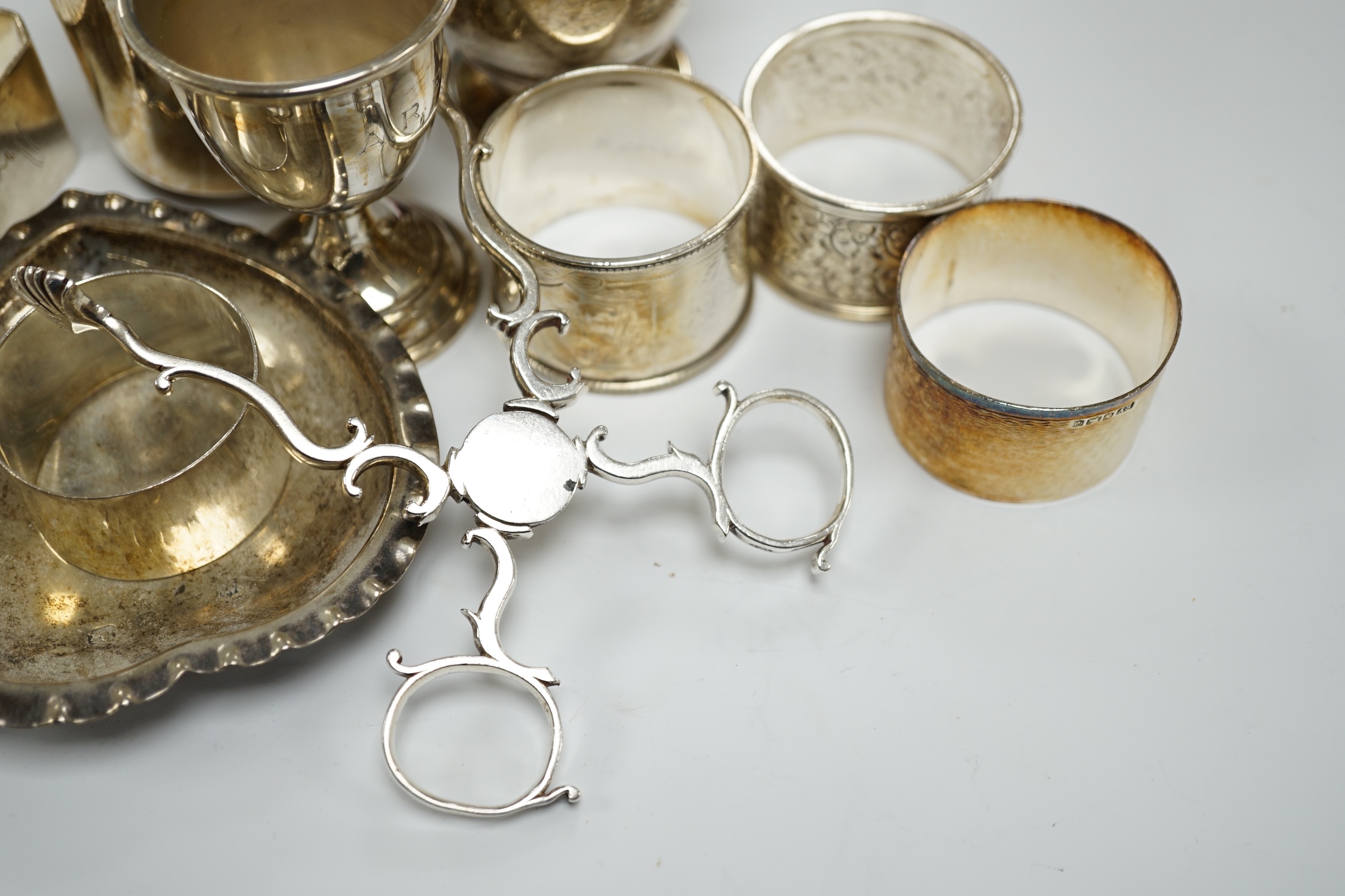 Assorted small silverwares including napkin rings, mugs, tea strainer and pair of Georgian sugar nips.